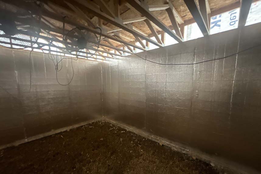Interior of a residential basement under construction with rigid foam board insulation installed on all walls by Cullen Insulation.