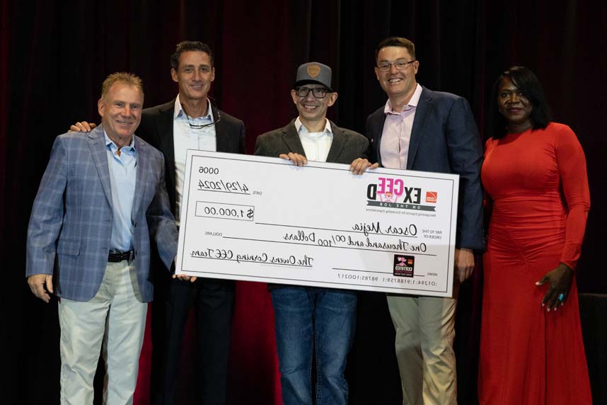 Oscar Mejia of Cullen Insulation, wearing a high‑visibility vest and safety glasses, smiles while holding the Owens Corning® Certified Energy Expert® “Installer of the Year” award at the 2025 National CEE Meeting in Carlsbad, California.